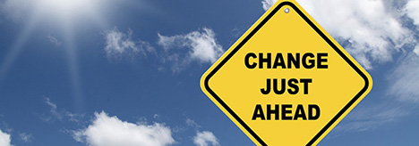 Image of blue sky with white clouds and a yellow road sign with the words