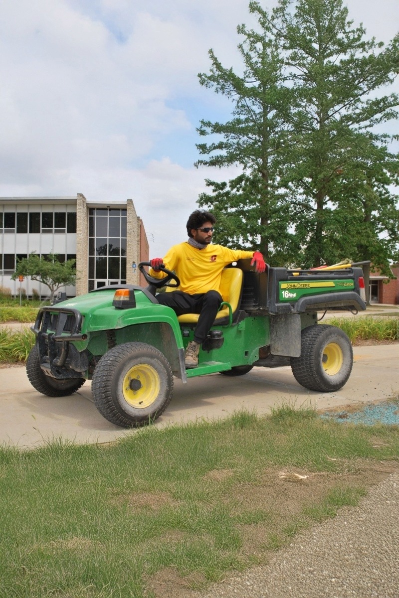 Landscape Student Employee Landscape Student Employee sits on John Deere gator