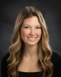 A woman with long blonde hair, smiling for a professional headshot.